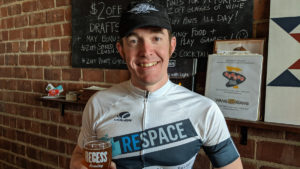 Ryan is a little tired yet manages to enjoy his post ride 2019 Broken Spoke IPA and muster a smile at Recess Brewing after the Broken Spoke Brew Ride.