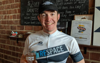 Ryan is a little tired yet manages to enjoy his post ride 2019 Broken Spoke IPA and muster a smile at Recess Brewing after the Broken Spoke Brew Ride.