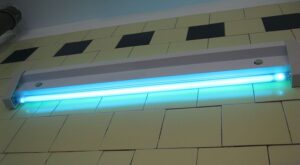 UV light mounted on white subway tile wall